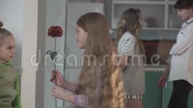 穿绿色睡衣的小男孩把花送给了姐姐，大女孩的背景是把花送给了姐姐